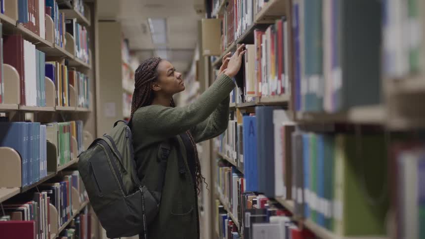 A teenager looks at books in a library