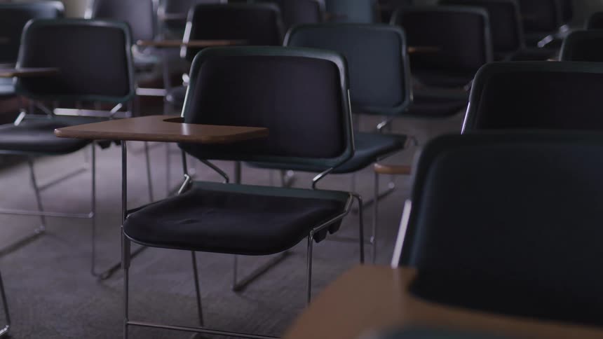 Rows of empty desks in a classroom