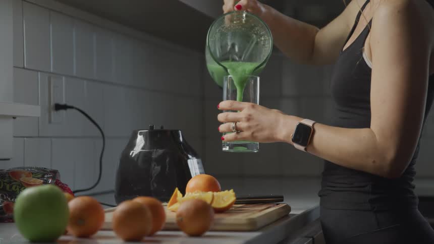 A woman pours a smoothie