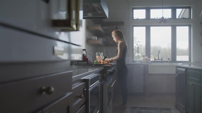 A woman is cooking food in a kitchen