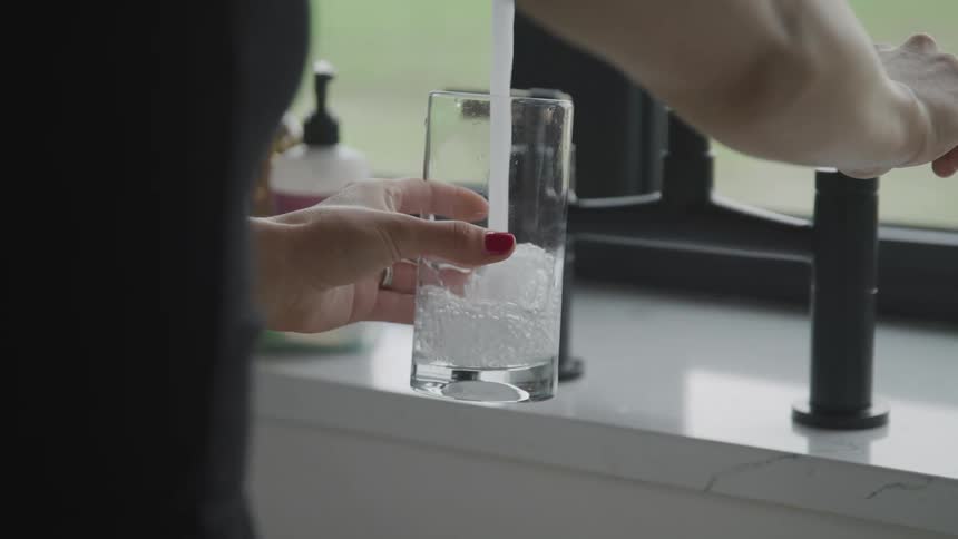 A person is filling a glass with water