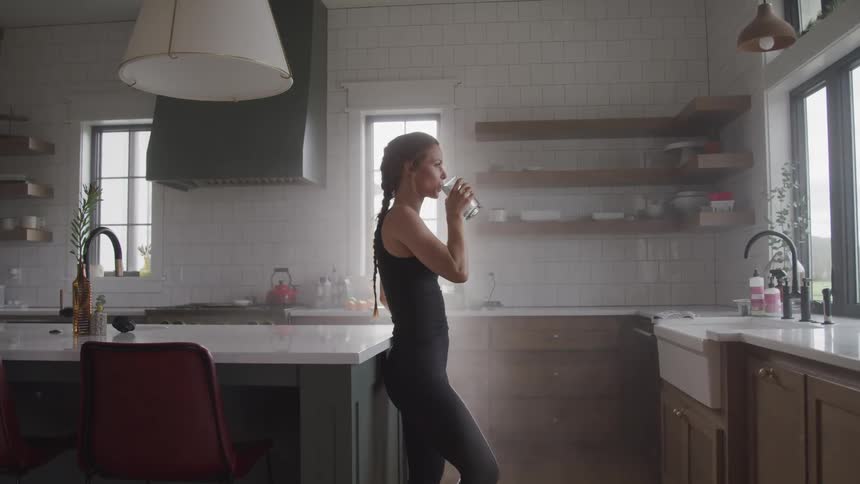 A woman drinking a glass of water athome