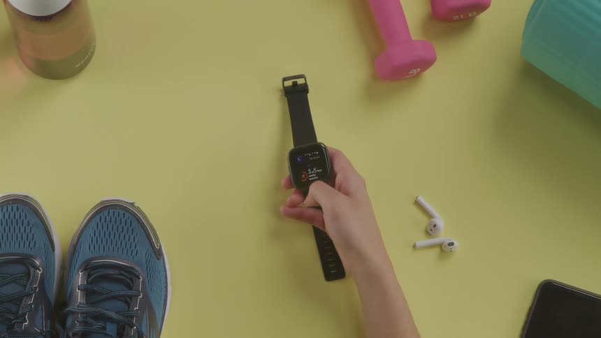 A female sets her watch as she prepares to exercise