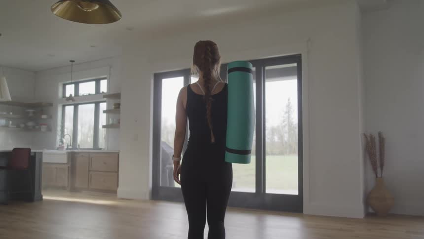 A woman is walking while holding exercise equipment