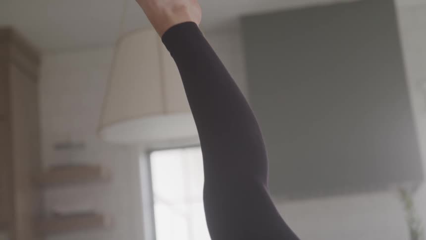 A woman is stretching indoors