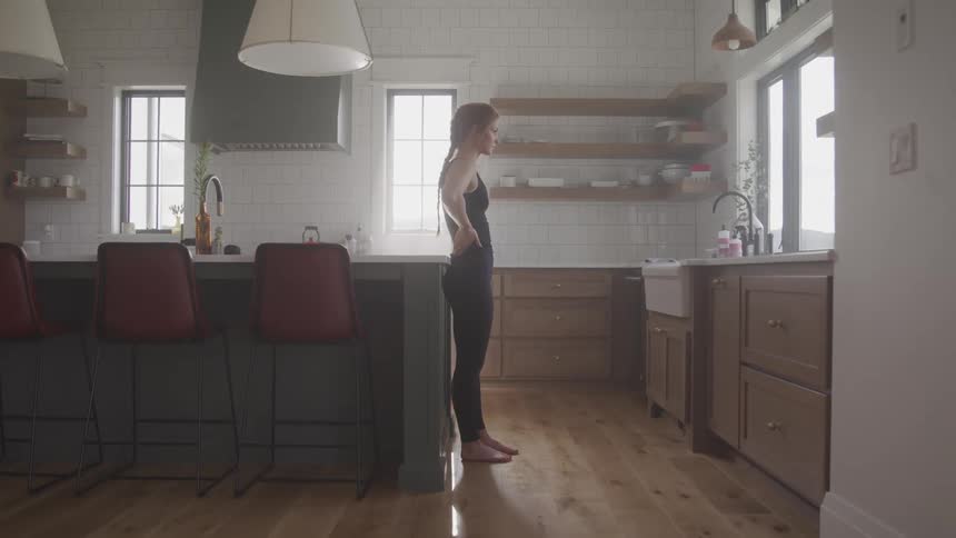 A woman stands in the kitchen