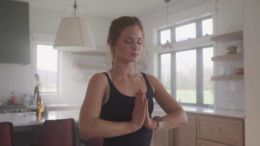A woman is doing a yoga pose indoors