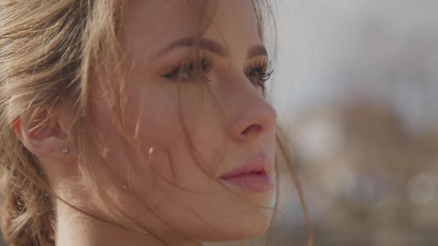 Side view of a woman with a brown ponytail looking up