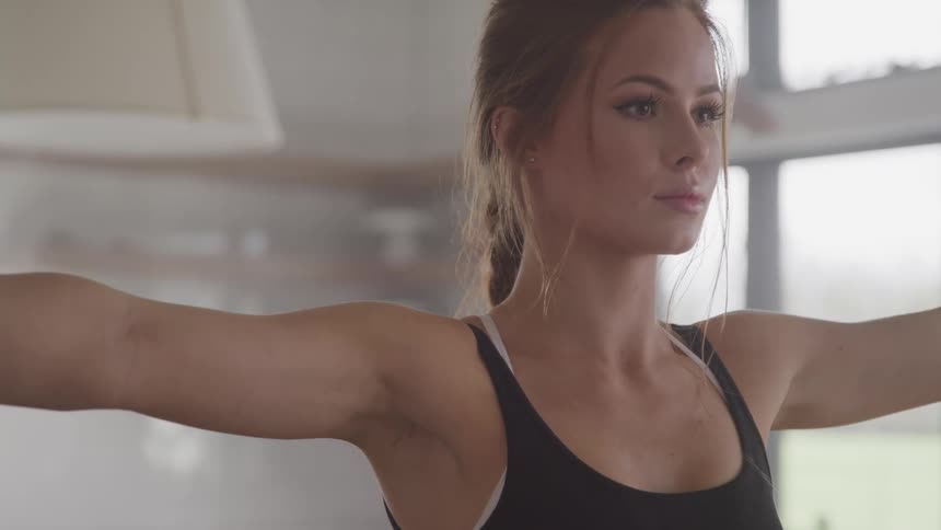 A teenage girl exercises at home