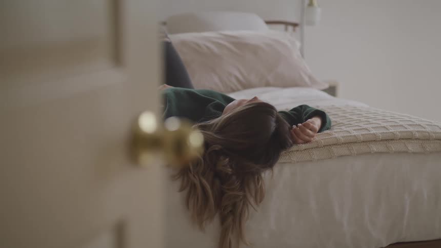 A teenager lying on her bed