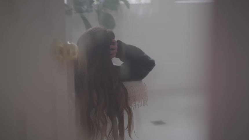 Out of focus footage of a woman reclined in a couch on the living room