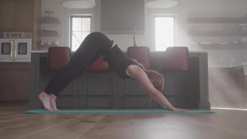 A woman is doing yoga in her home