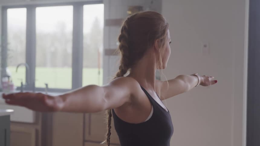 A woman is streching inside her house