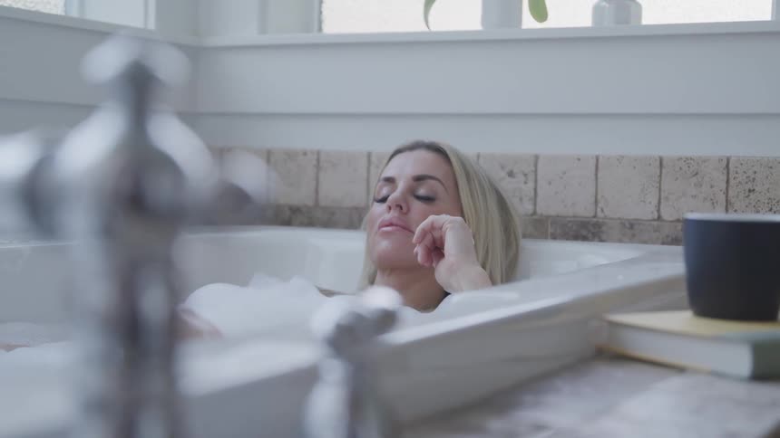 A young woman soaking in a bathtub