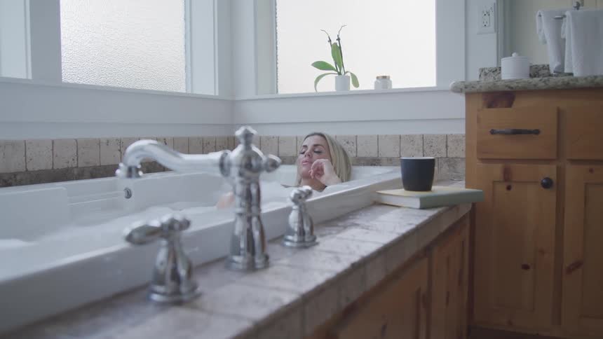 Woman relaxing in a bubble bath in bathtub