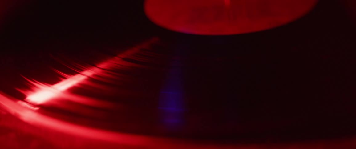 Colored lights reflect on a turning record album