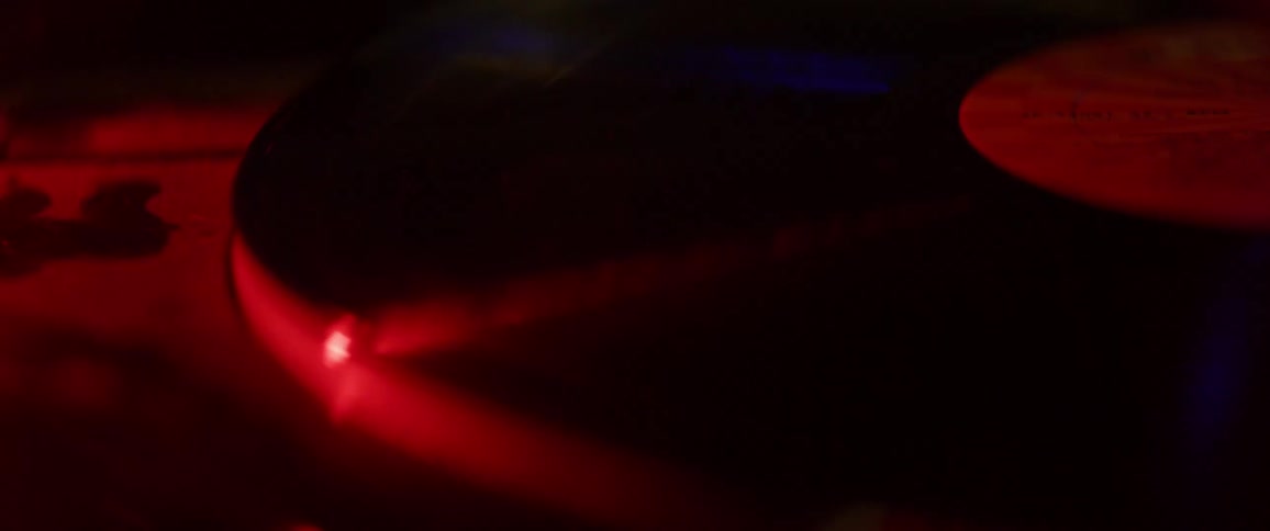 A red light shines on a spinning record