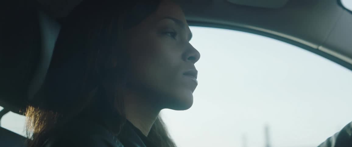Woman drives a vehicle past a blue truck