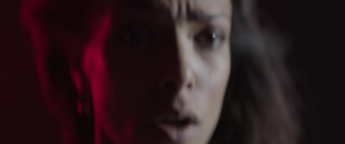 Wind blows through a woman's hair as she stares at something shocking