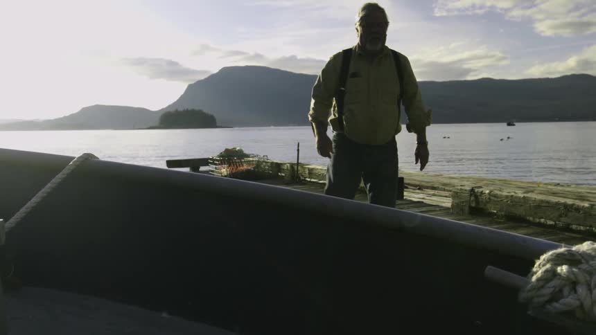 A man stands next to a mountain lake