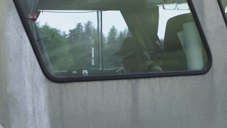 A man sits in the cockpit of a vehicle that is swaying to and fro