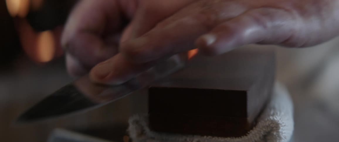 Person sharpens a knife on a black block