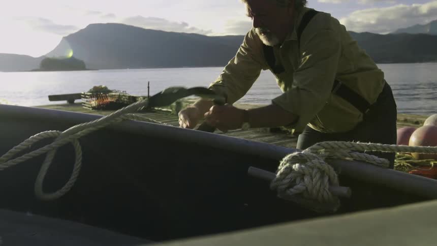 A man pulling rope from a boat
