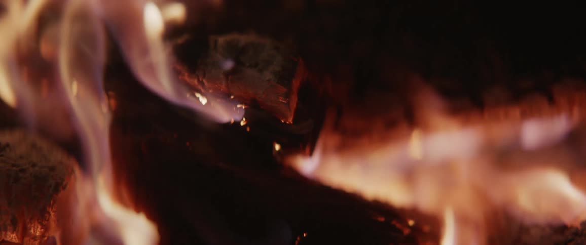 A piece of wood burns in the dark