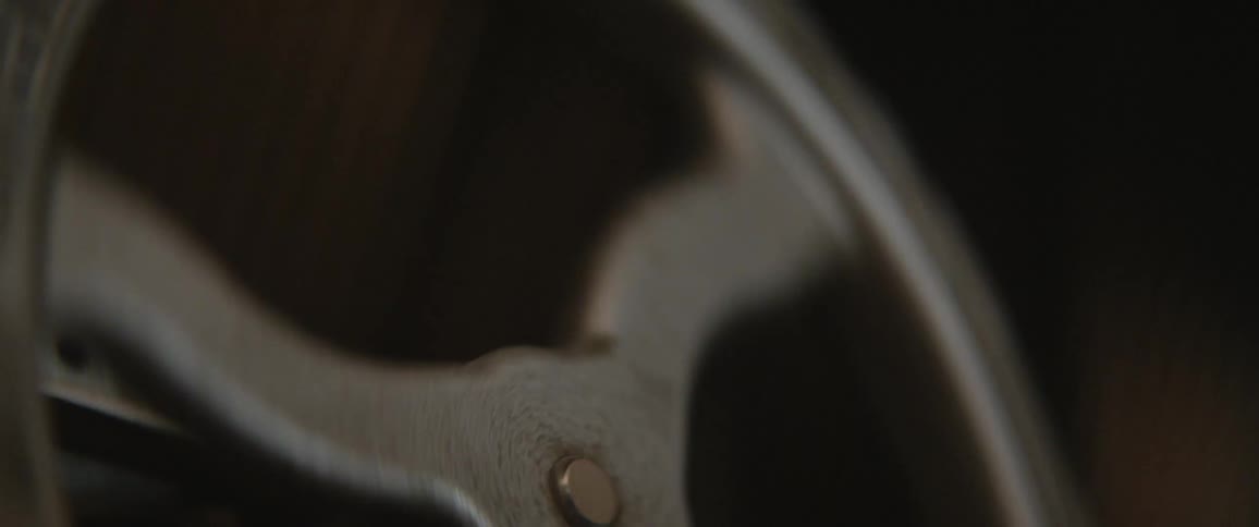 A man turns an old style mechanism wheel