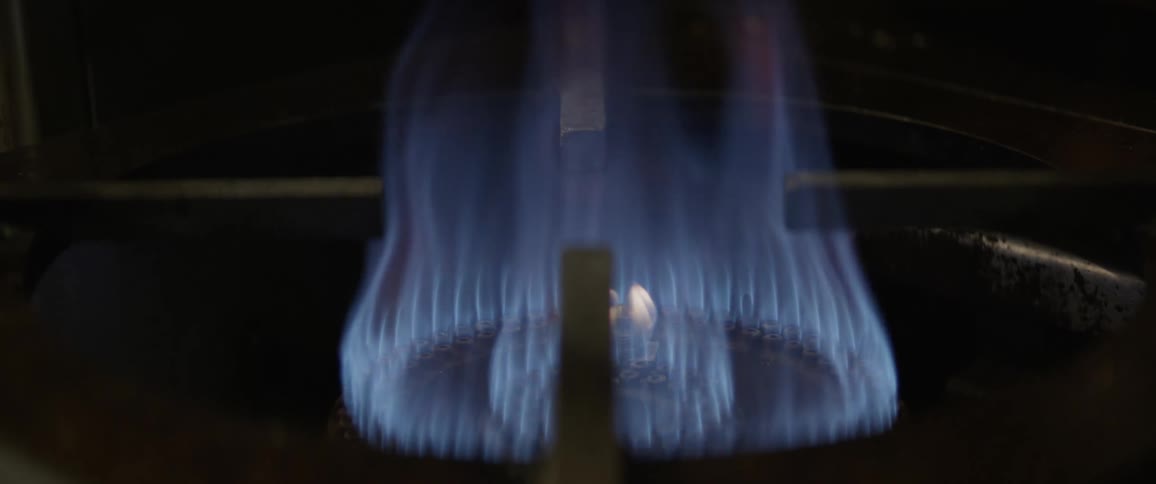 A flame burns on a gas stove