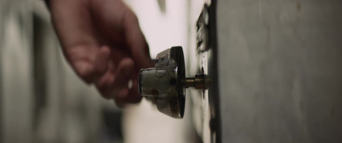 A man turns the knob on the stove