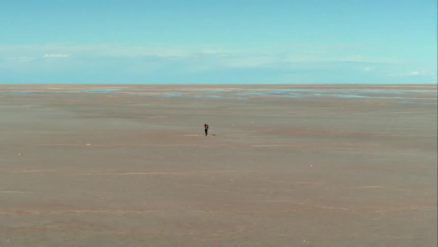 A person is hiking in the sand, aerial