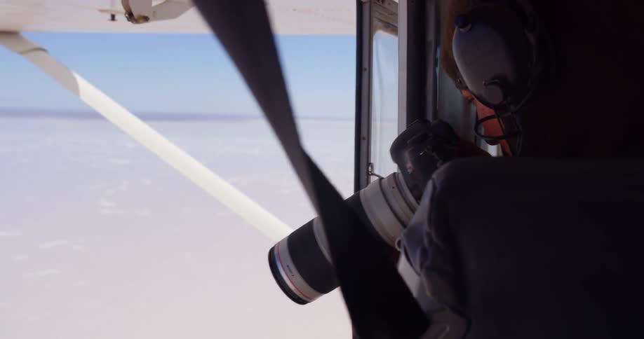 A woman taking photos from an airplane
