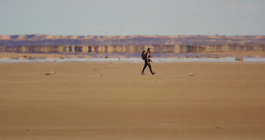 A woman hiking across the desert