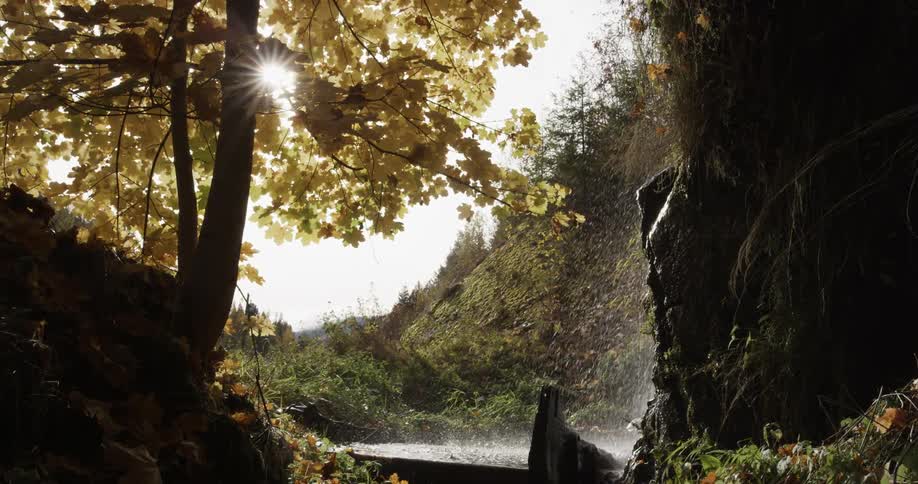 A stream flowing over a cliff in nature on an autumn day