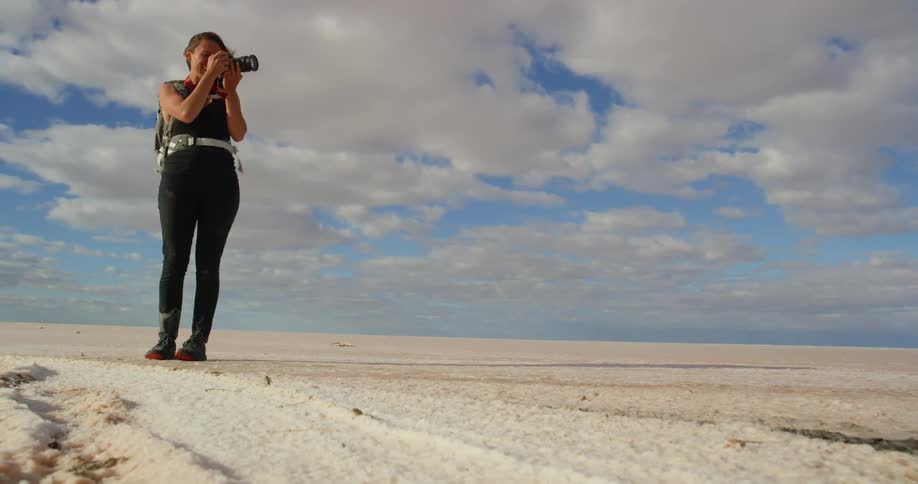 A young woman takes pictures in the desert