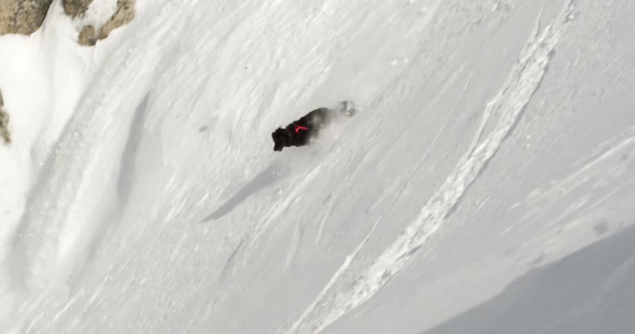 A dog running down a steep snowy hill