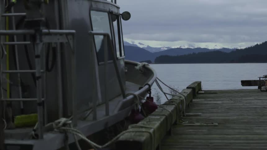 A boat sits docked on a cloudy day