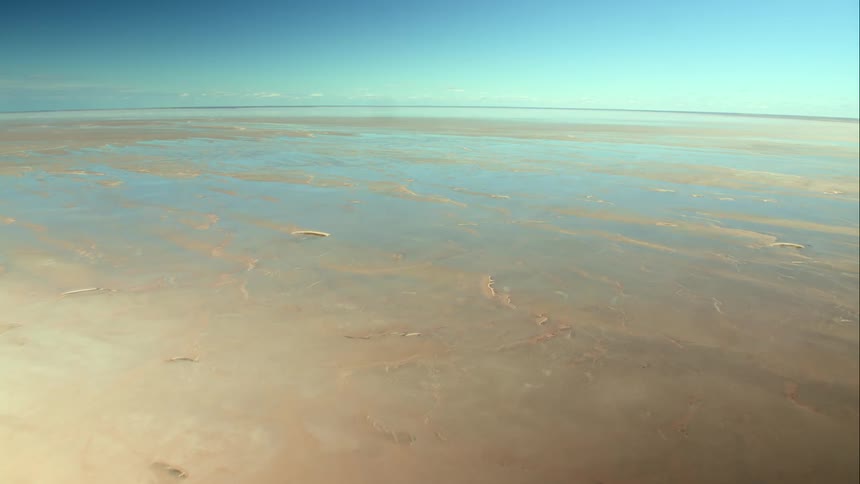 Aerial view of the desert salt flats expanding to the horizon on a clear day