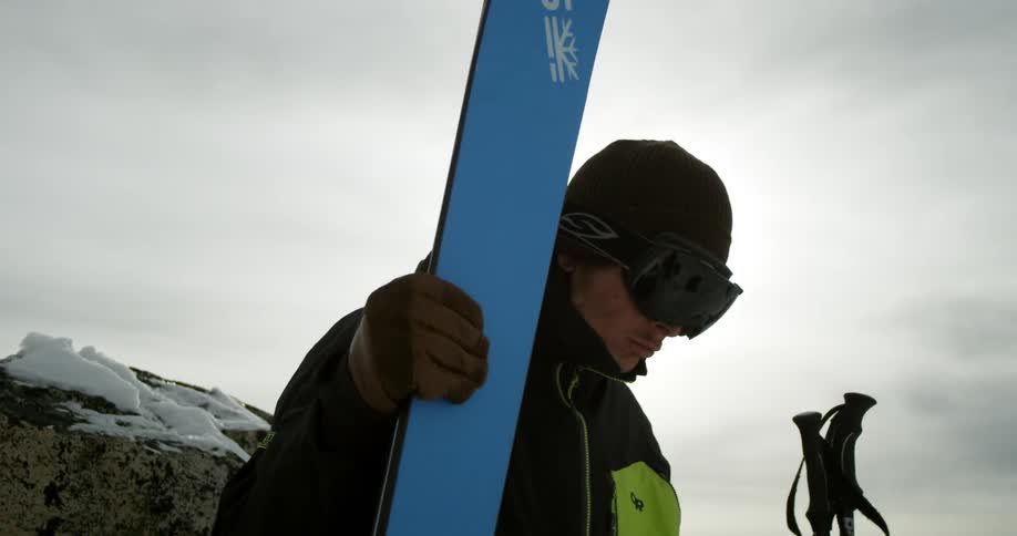 A man picking up his skis and poles