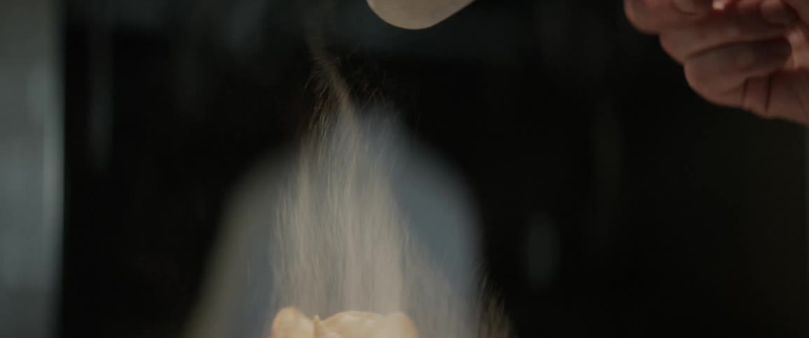Powdered sugar is dropped onto a dish
