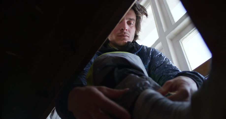 Man sitting on a chair puts on winter gear