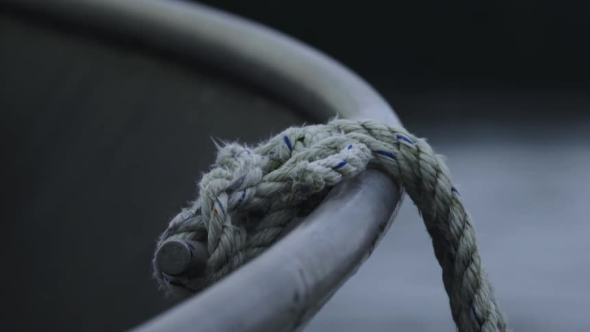 A rope hangs over the edge of a bobbing boat