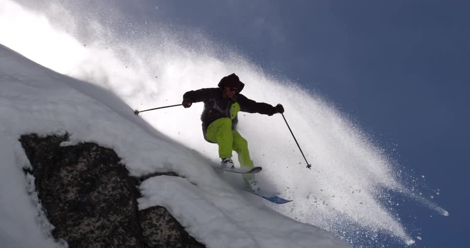 A skier daringly skis down an incredibly steep snow covered slope