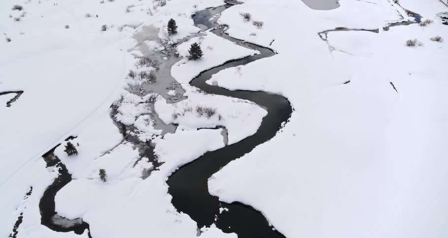 Aerial view of a river on snow covered ground