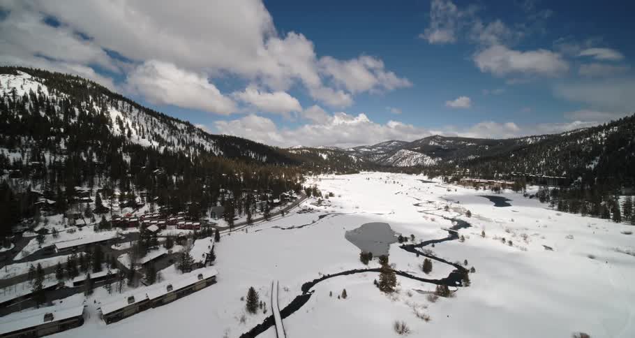 Aerial view of a snow covered forest and valley
