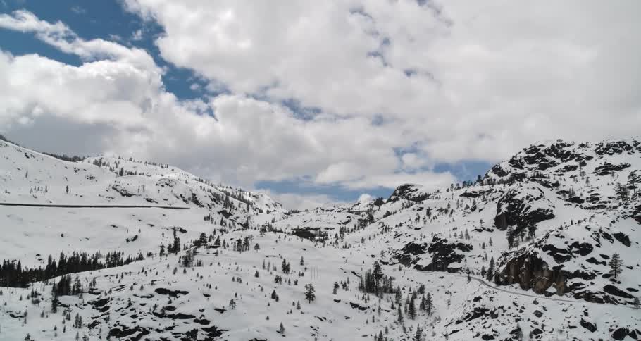 A snow covered mountain valley dotted with evergreen trees