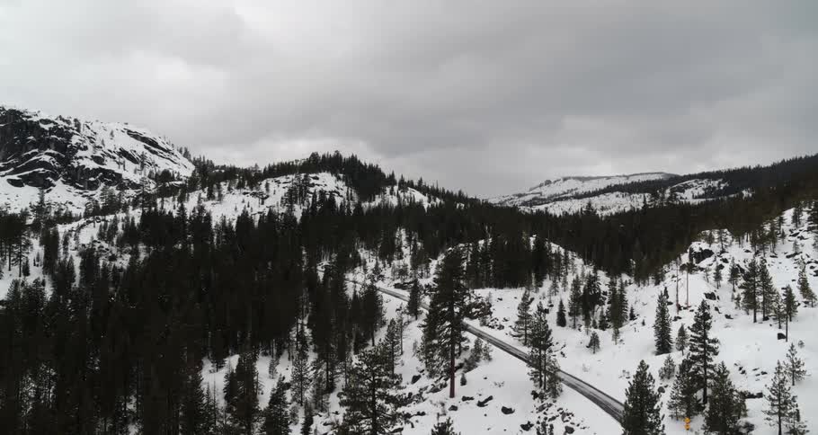 An aerial view of snowy mountains on a cloudy winter day