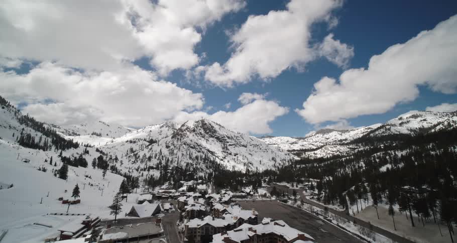 A small town in a valley between mountains covered in snow