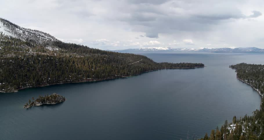 A aerial view with a body of water and the forest and mountains along the coast